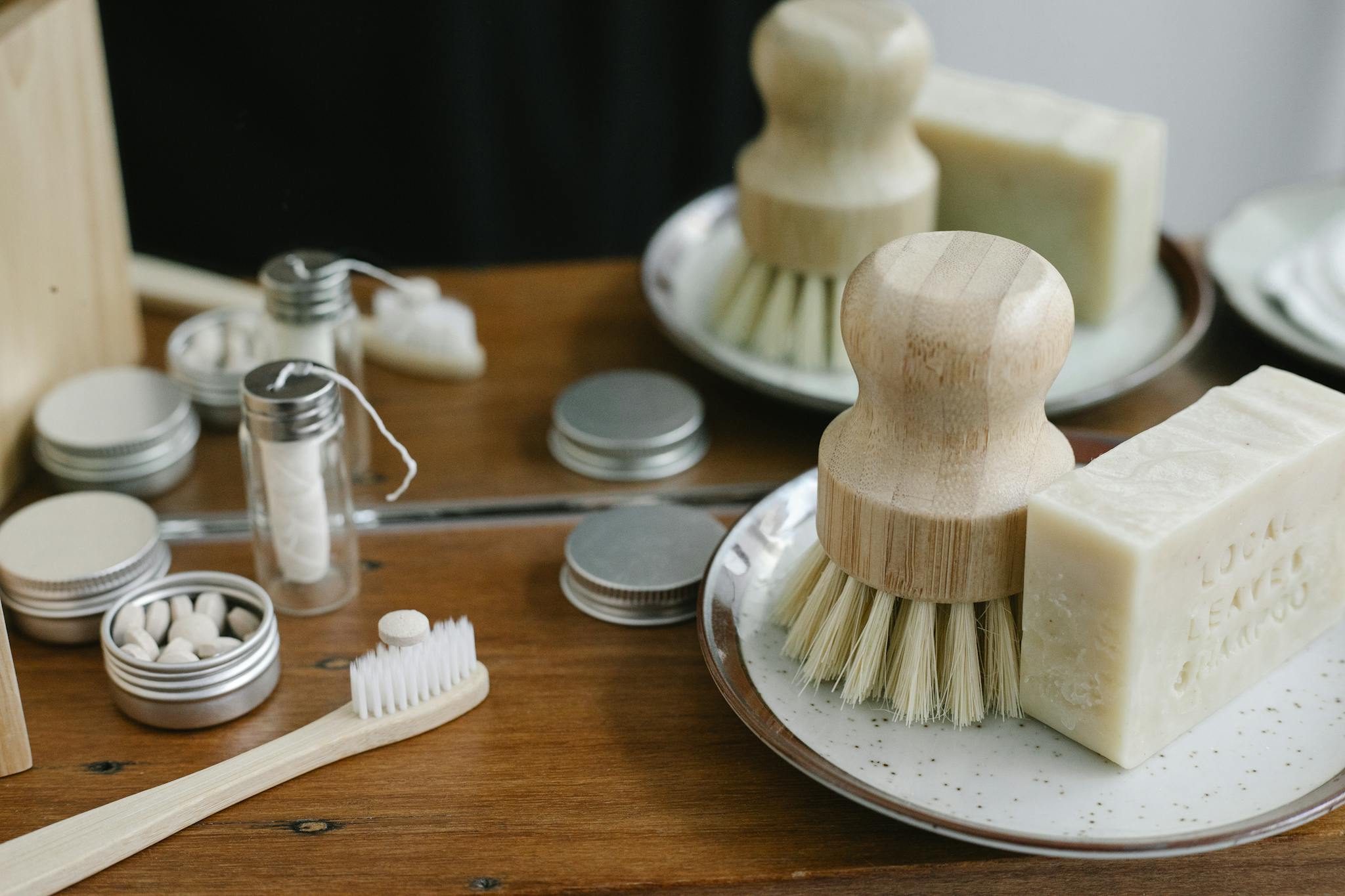 Eco-friendly bathroom essentials including bamboo toothbrush, soap, and reusable containers.